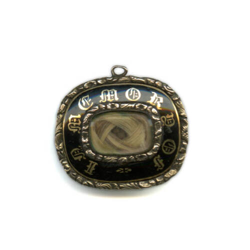 Metal pendant with a tiny glass window that shows blonde hair in the pendant.